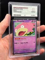 Handheld close-up of English Slowpoke #086 Black Star Promo 2026 Pokémon card in an ACE 8 Near Mint/Mint slab, showing artwork and grading label